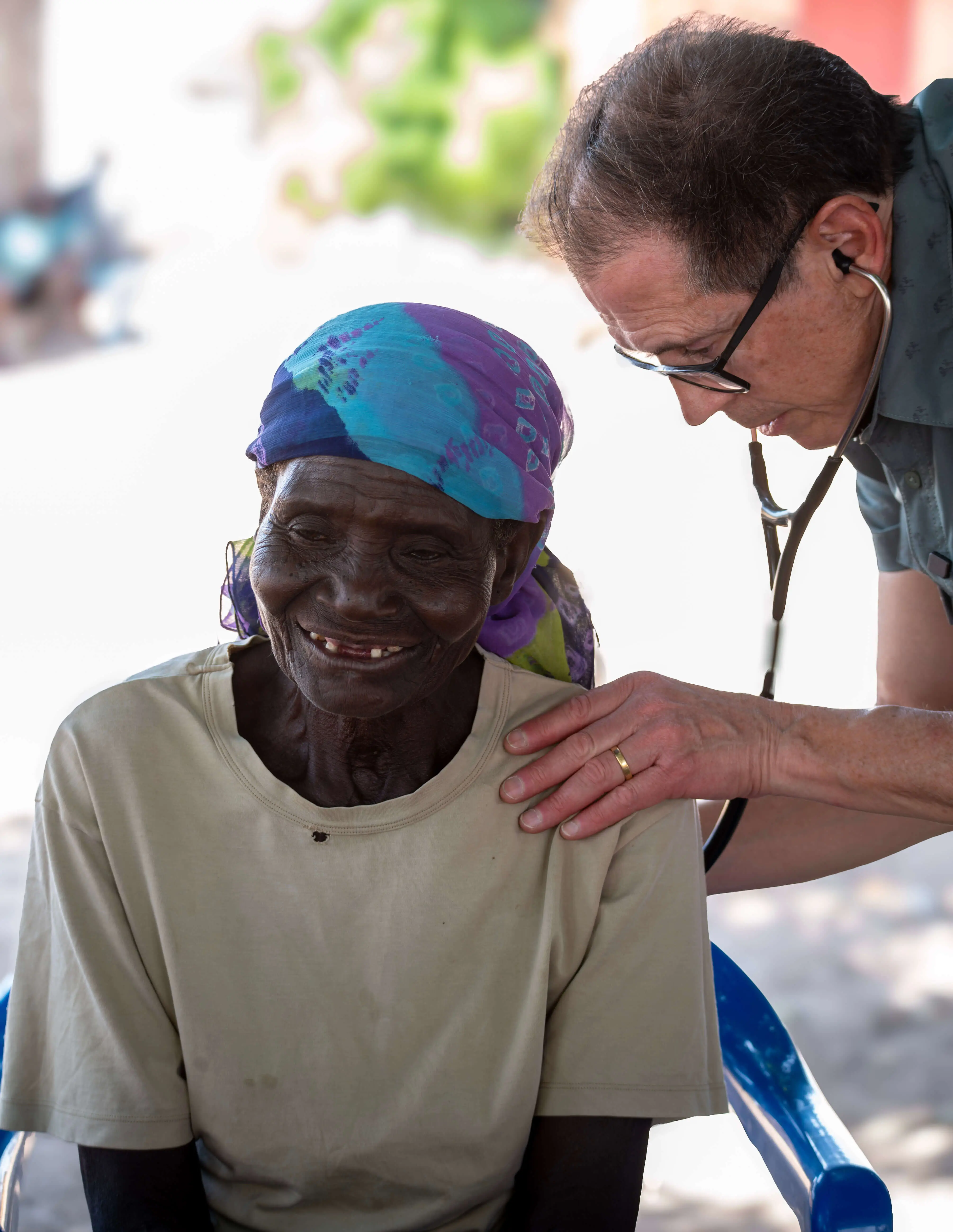 A Healing Kadi doctor checking a woman's lungs.